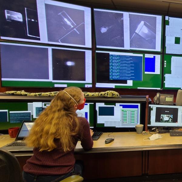 Two scientists in a control room full of computer monitors that allow them to adjust diamond mirrors in their CBXFEL experiment