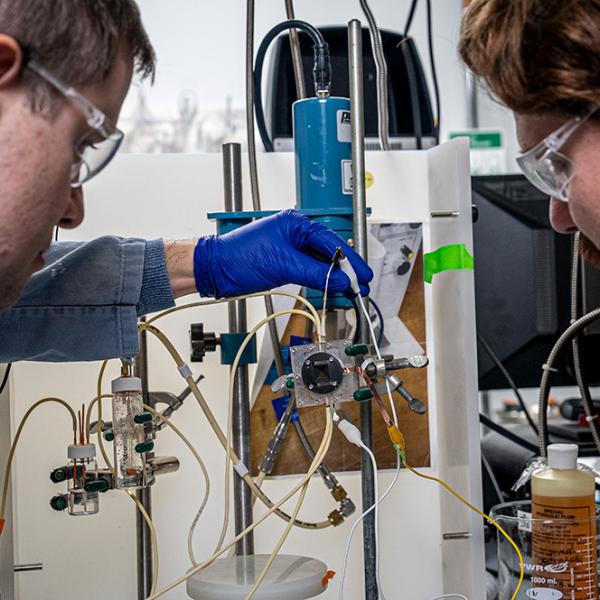 Walter Drisdell and Aidan Coffey of Berkeley Lab’s Chemical Sciences Division at Berkeley Lab’s LiSA research facility adjusting a pump that flows liquid through the electrochemical cell