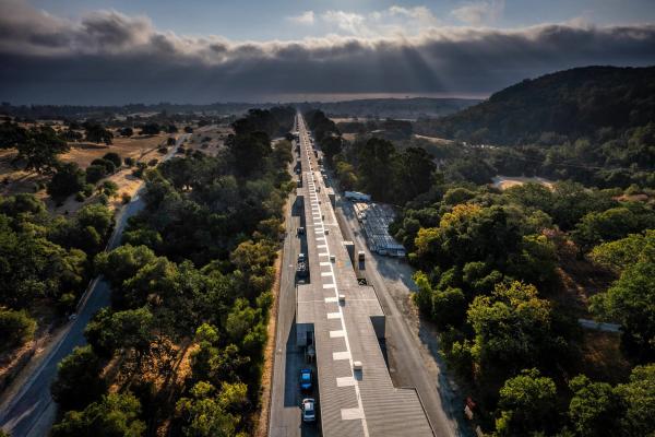A narrow two-mile long building stretches through trees and foothills.